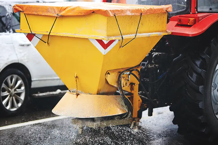 professional ice management, spreading salt to melt ice on commercial parking lot - Springfield, IL