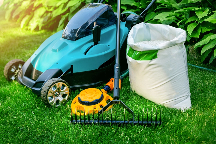 Gardening tools and lawn care equipment on the green grass of a healthy lawn in Springfield, IL.